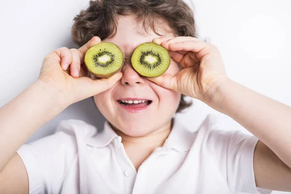 Gyönyörű fiú gyermek gazdaság kiwi — Stock Fotó