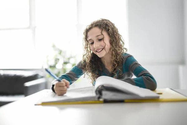 Девочка 9 лет в школьной форме домашнее задание — стоковое фото