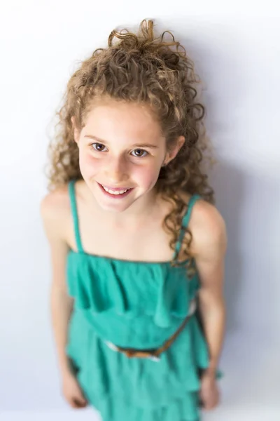 Retrato de niña feliz, sonriente, segura de sí misma de 9 años con el pelo rizado, aislada en gris — Foto de Stock