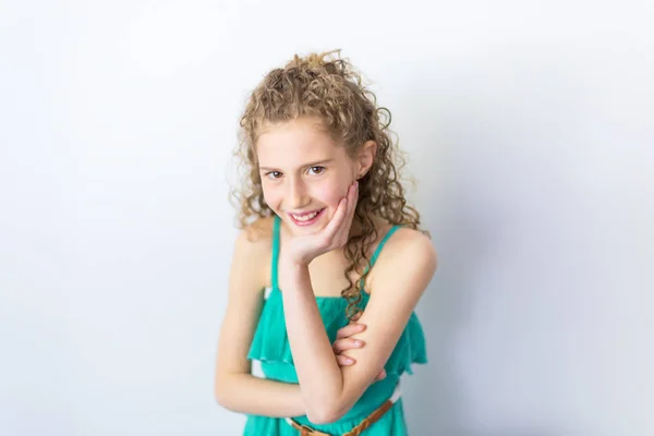 Portret szczęśliwy, uśmiechnięty, pewnie 9 lat dziewczyna z kręconymi włosami, na szarym tle — Zdjęcie stockowe