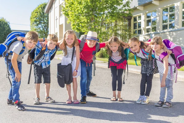 Porträt von Schülern außerhalb des Klassenzimmers, die Taschen tragen — Stockfoto