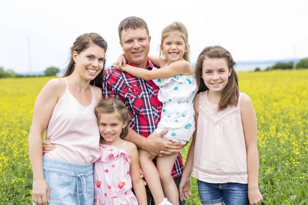 Familjen utomhus på ett gult fält — Stockfoto
