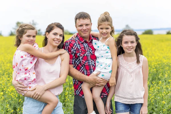 Familjen utomhus på ett gult fält — Stockfoto