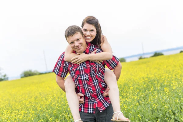イエロー グリーン上幸せな笑顔若いカップル レイプ草原 — ストック写真
