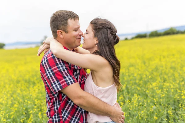 Spokojený úsměv mladý pár nad žlutá zelená znásilnění Louka — Stock fotografie