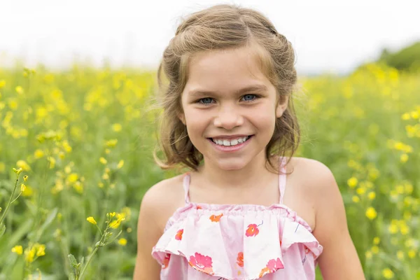 Šťastná dívka v oblasti žluté květy — Stock fotografie