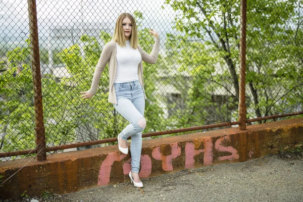 Красива молода жінка стоїть біля паркану ланцюга — стокове фото