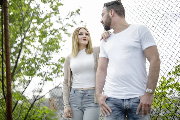 Couple close to a fence in a day — Stock Photo, Image