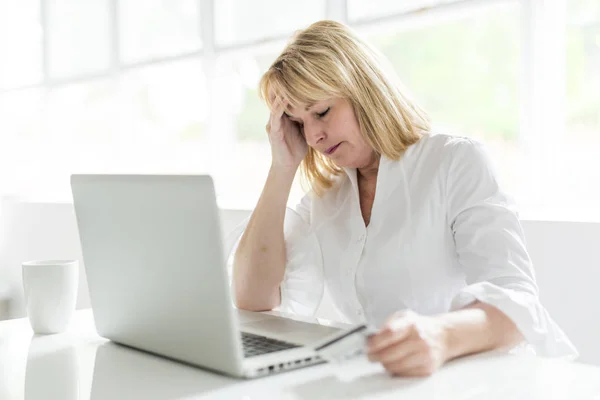 Mujer madura usando el ordenador portátil en casa — Foto de Stock