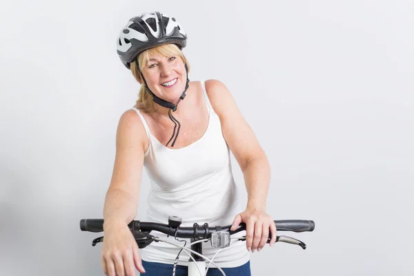 Anziana donna sul lato di una bicicletta in studio sfondo bianco — Foto Stock