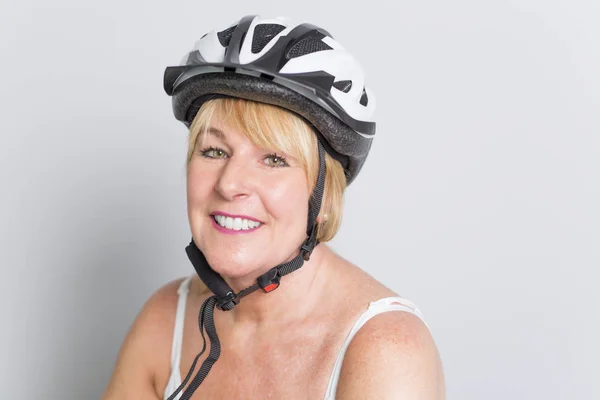 Senior woman on the side of a bike in studio white background — Stock Photo, Image