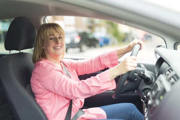 Glad och leende senior kvinna i svart bil — Stockfoto