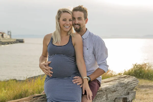 Беременная женщина на пляже с мужем развлекается — стоковое фото