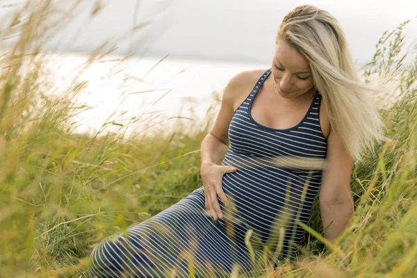 浜辺の脇に若い美しいブロンド妊娠女性の肖像画 — ストック写真