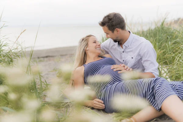 Zwangere vrouw op strand met echtgenoot plezier — Stockfoto