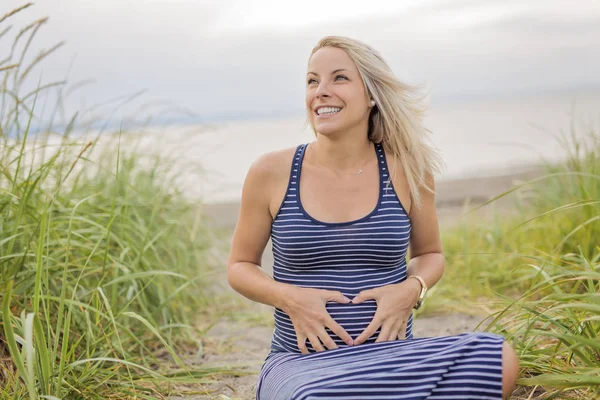 Porträt einer jungen schönen blonden schwangeren Frau am Strand — Stockfoto