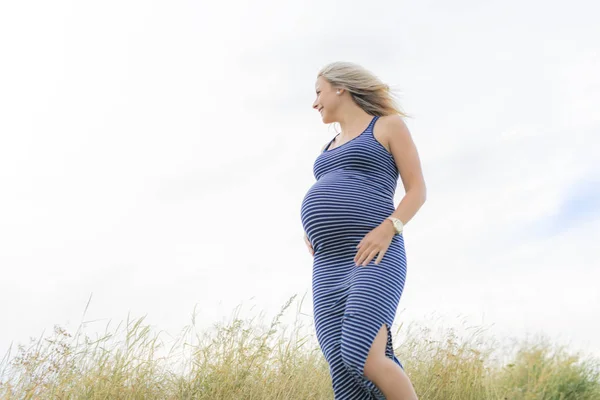 Portrait of a young beautiful blond pregnant woman on the side of the beach — Stock Photo, Image