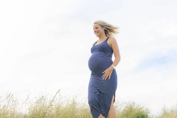 Genç güzel sarışın bir hamile kadın plaj kenarında portresi — Stok fotoğraf