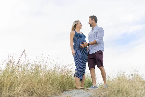 Pregnant woman at beach with husband having fun — Stock Photo, Image