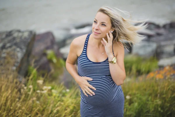 Portret van een jonge mooie blonde zwangere vrouw aan de kant van het strand — Stockfoto