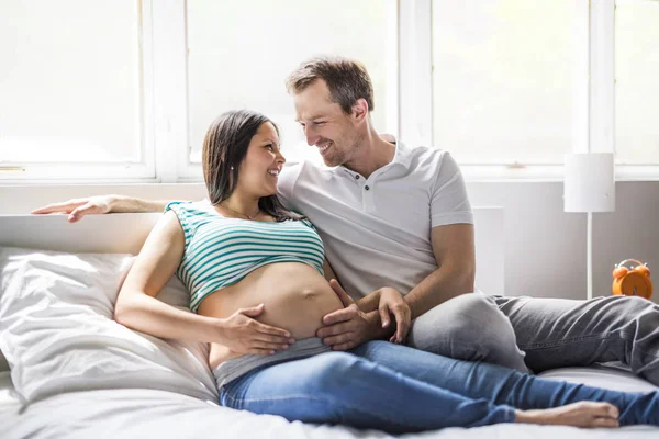 Jeunes parents au lit attendant un petit bébé, Moments romantiques pour couple enceinte — Photo