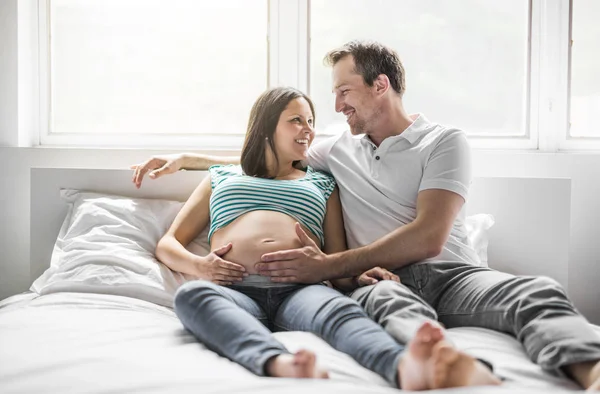 Νέοι γονείς στο κρεβάτι περιμένοντας ένα μικρό μωρό, ρομαντικές στιγμές για έγκυος ζευγάρι — Φωτογραφία Αρχείου