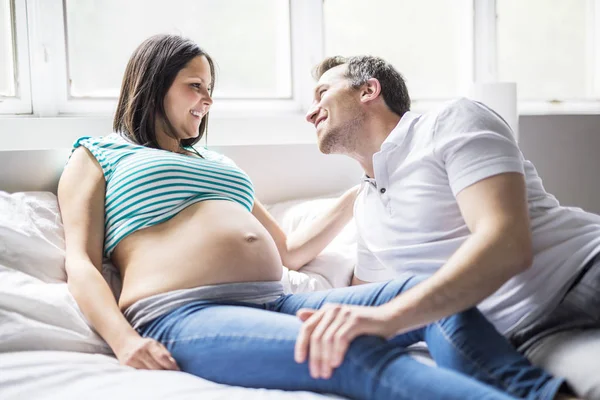 Jonge ouders in bed verwacht een beetje baby, romantische momenten voor zwangere paar — Stockfoto