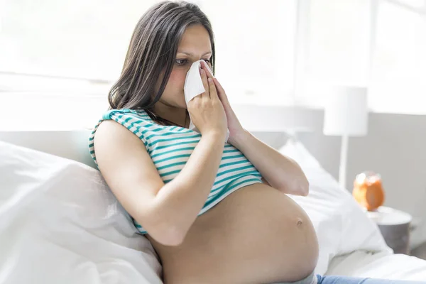 Hamile kadın grip ile evde bir yatakta yatarken süre poz — Stok fotoğraf
