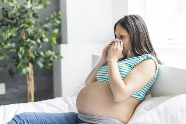 Hamile kadın grip ile evde bir yatakta yatarken süre poz — Stok fotoğraf