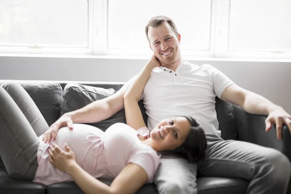 妊娠中の女性がソファでリラックスして — ストック写真