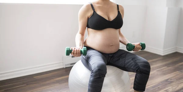 Zwangere vrouw training met halters actief te blijven — Stockfoto