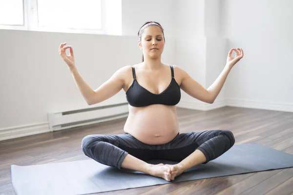 Pregnant woman doing stretching and yoga at home — Stock Photo, Image