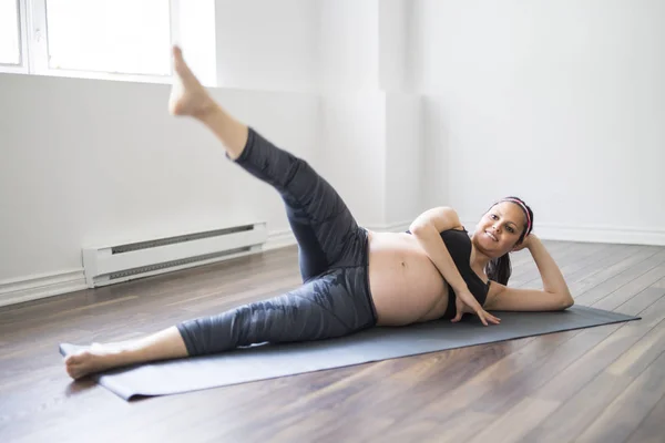 Donna incinta che fa stretching e yoga a casa — Foto Stock