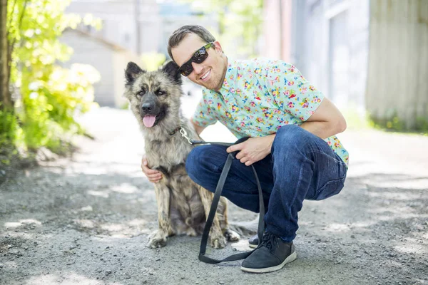 Sorrindo homem andando seu animal de estimação no bairro — Fotografia de Stock