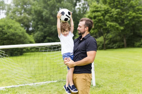 Far med son spela fotboll på fotbollsplan — Stockfoto