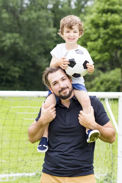 Padre con figlio giocare a calcio sul campo da calcio — Foto Stock