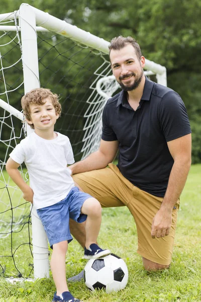 Far med son spela fotboll på fotbollsplan — Stockfoto