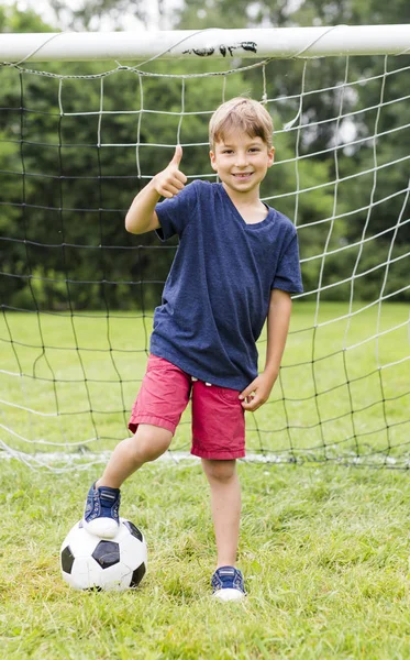 Młody chłopak z piłki nożnej na pole zabawy — Zdjęcie stockowe