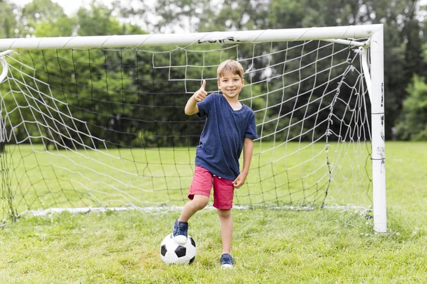 Joven con el fútbol en un campo de divertirse — Foto de Stock