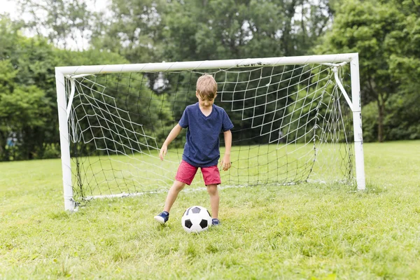 Joven con el fútbol en un campo de divertirse — Foto de Stock