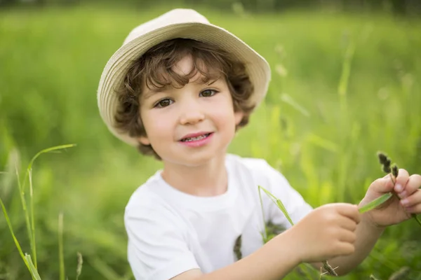 Portrait d'adorable garçon enfant avec chapeau debout sur une prairie d'été — Photo