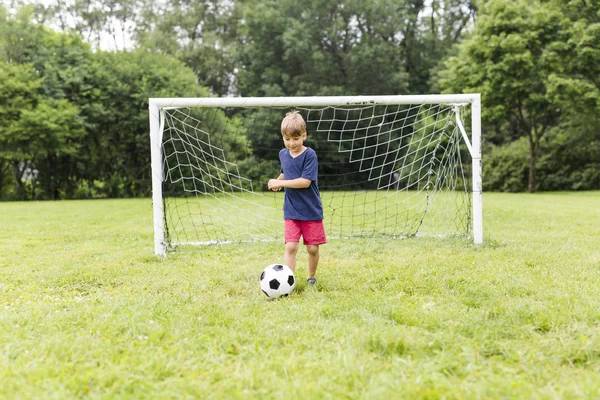 Joven con el fútbol en un campo de divertirse — Foto de Stock