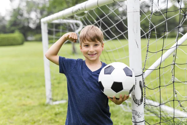 Junge mit Fußball auf dem Feld hat Spaß — Stockfoto