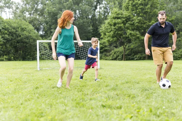 Χαρούμενη οικογένεια, παίζοντας ποδόσφαιρο στο πάρκο — Φωτογραφία Αρχείου