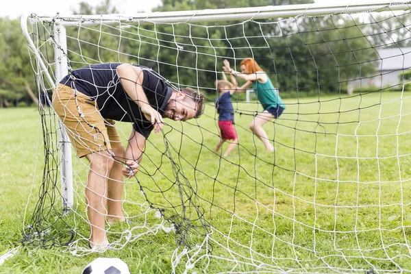 Vrolijke familie voetballen in een park — Stockfoto