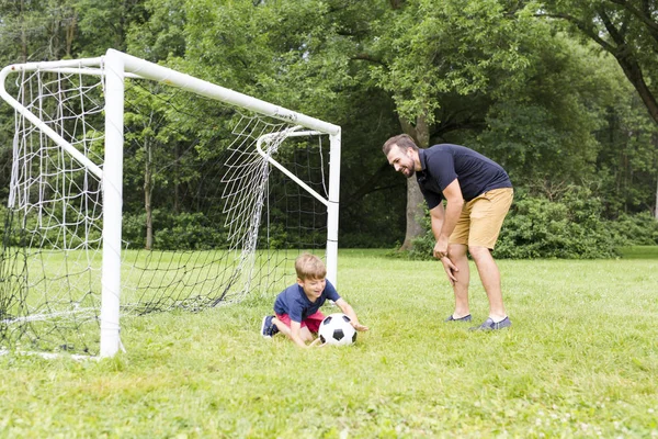 サッカーのピッチでサッカーの息子と父 — ストック写真