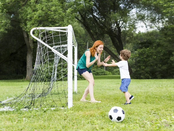 Obraz rodziny, matka i syn, grać w piłkę w parku — Zdjęcie stockowe