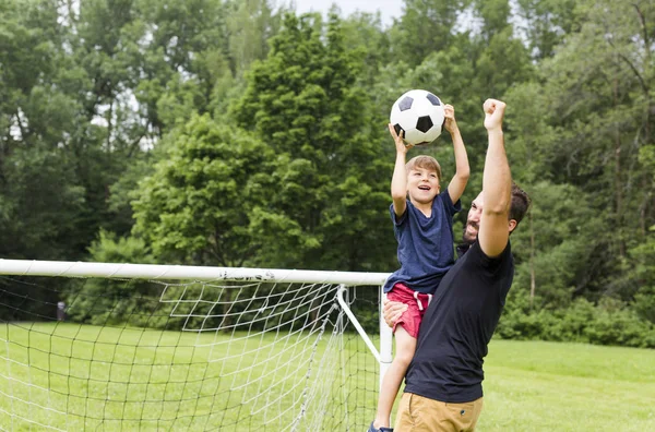 Padre con hijo jugando fútbol en campo de fútbol —  Fotos de Stock