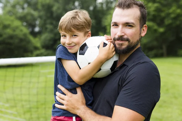 Padre con hijo jugando fútbol en campo de fútbol —  Fotos de Stock