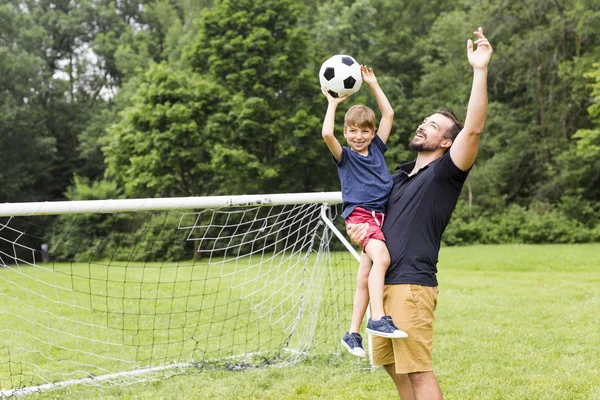 Far med son spela fotboll på fotbollsplan — Stockfoto